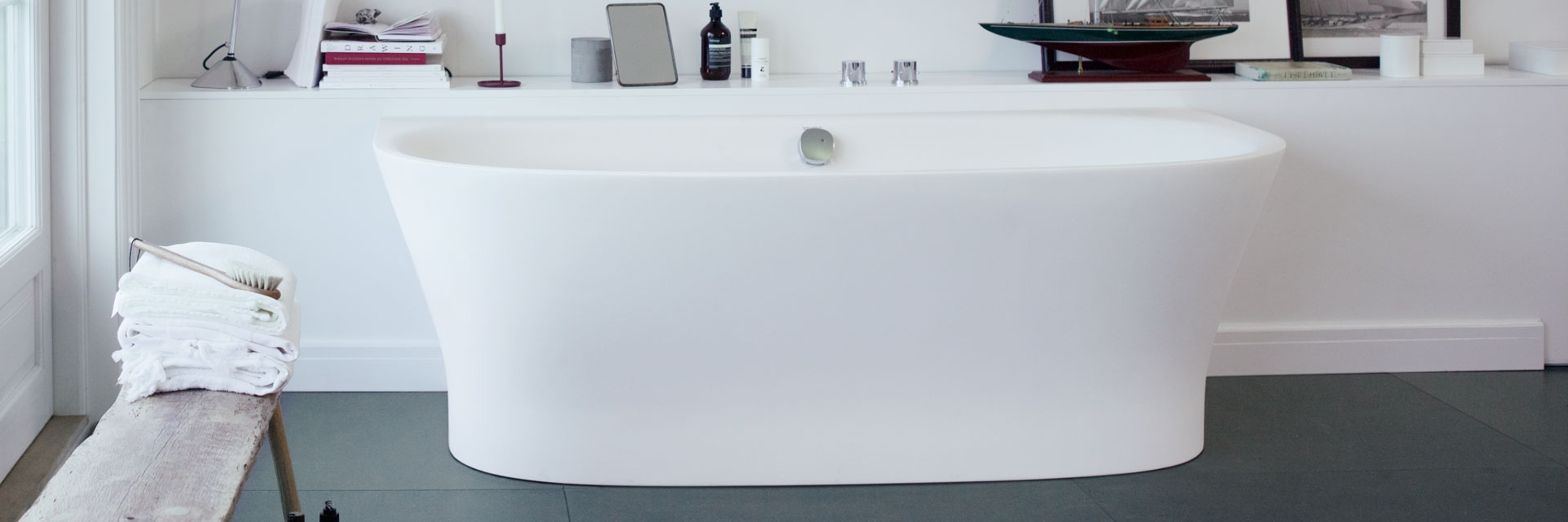 Freistehende Badewanne vor großer Fensterfront