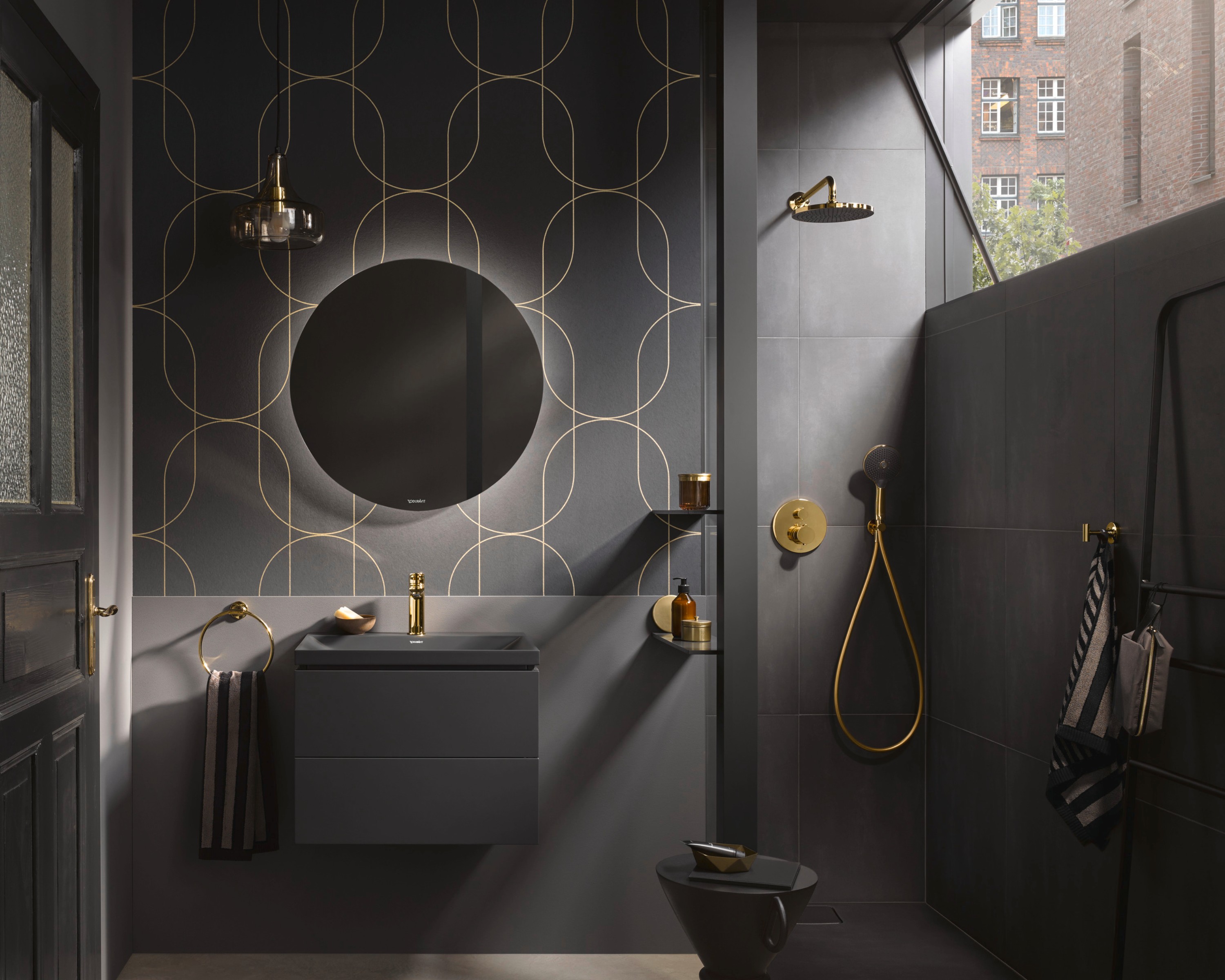 Duravit Vitrium Bad, dunkles Design mit goldenen Armaturen, Handtuchhaltern und Regalen; geometrische Muster an den Wänden