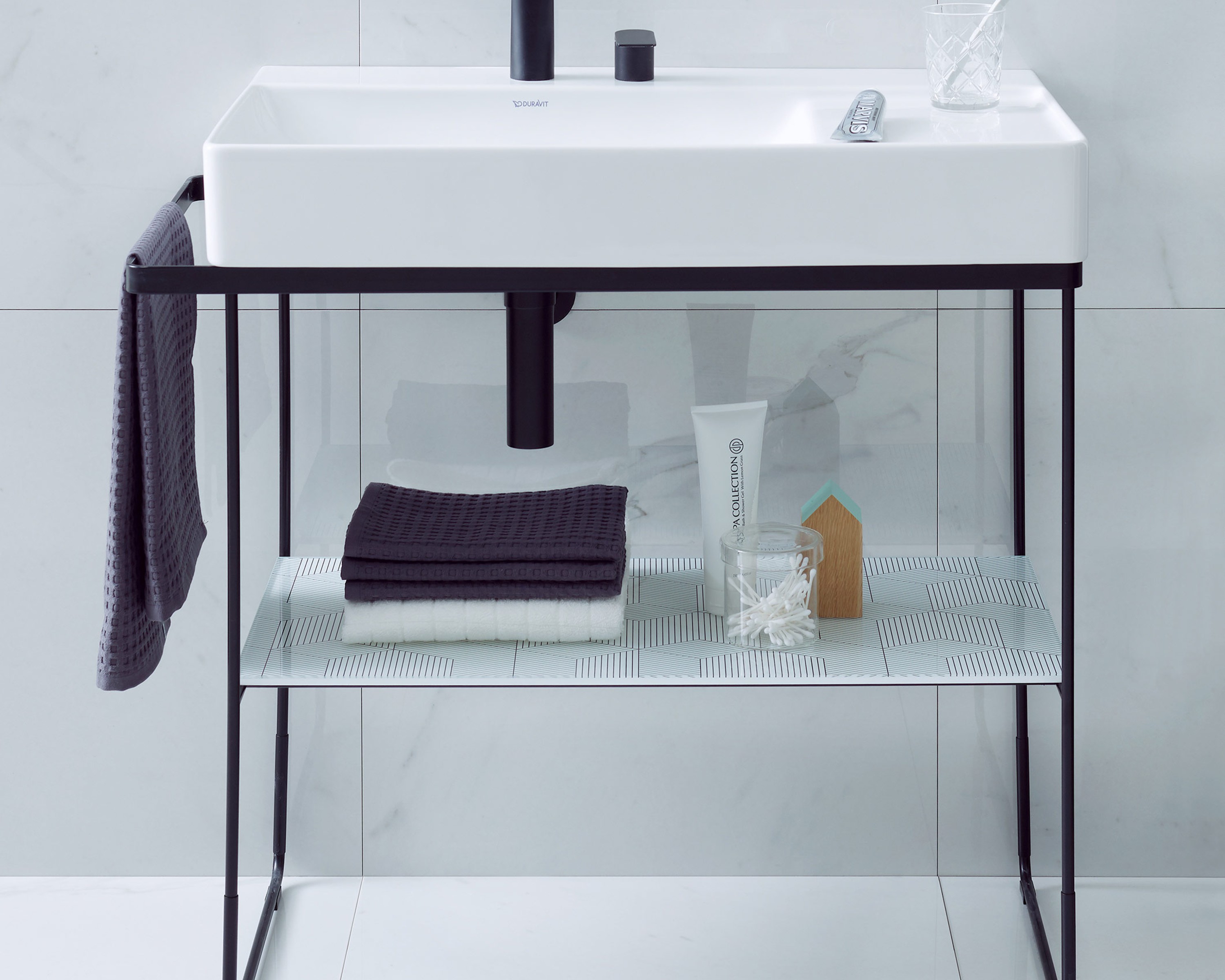 Duravit sink with black base cabinet, toothpaste, and toothbrush in a modern bathroom