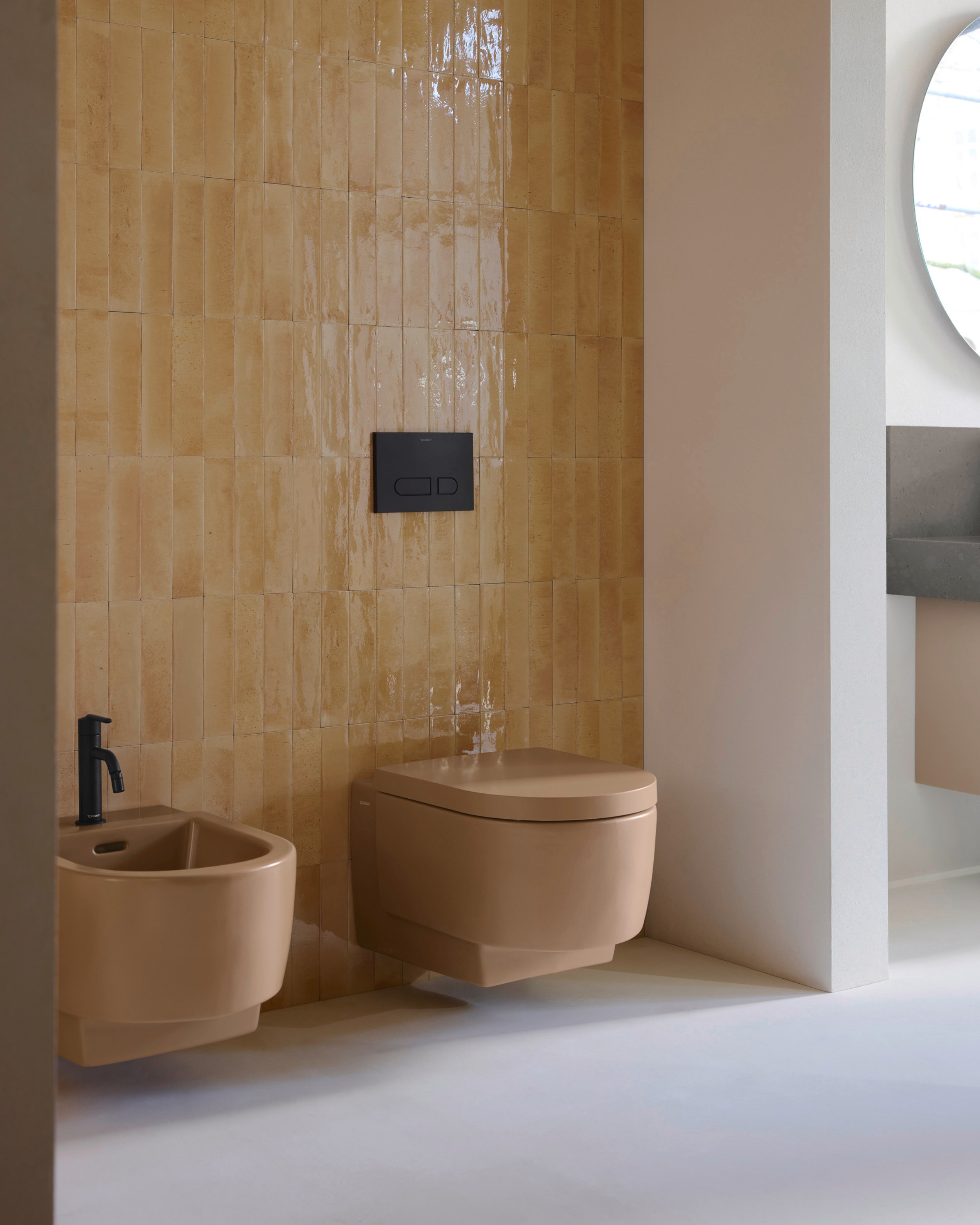 Toilet and bidet from the Duravit Balcoon series in earth tones with black faucets