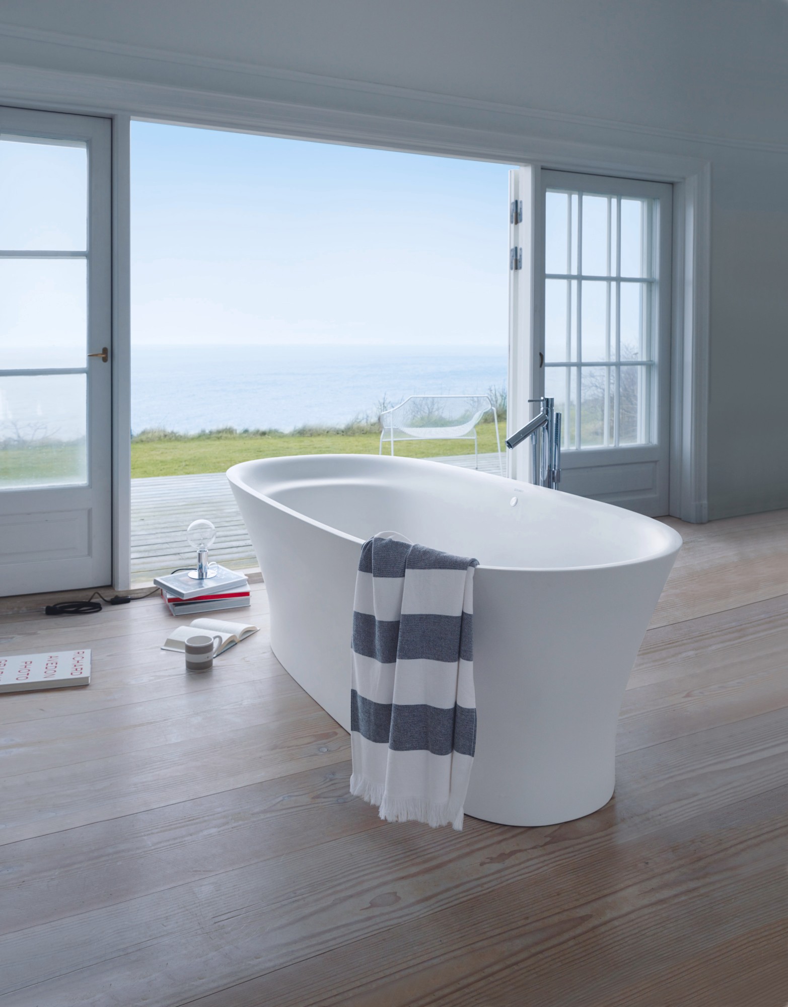 Freistehende Duravit Cape Cod Badewanne vor bodentiefem Fenster mit Meerblick