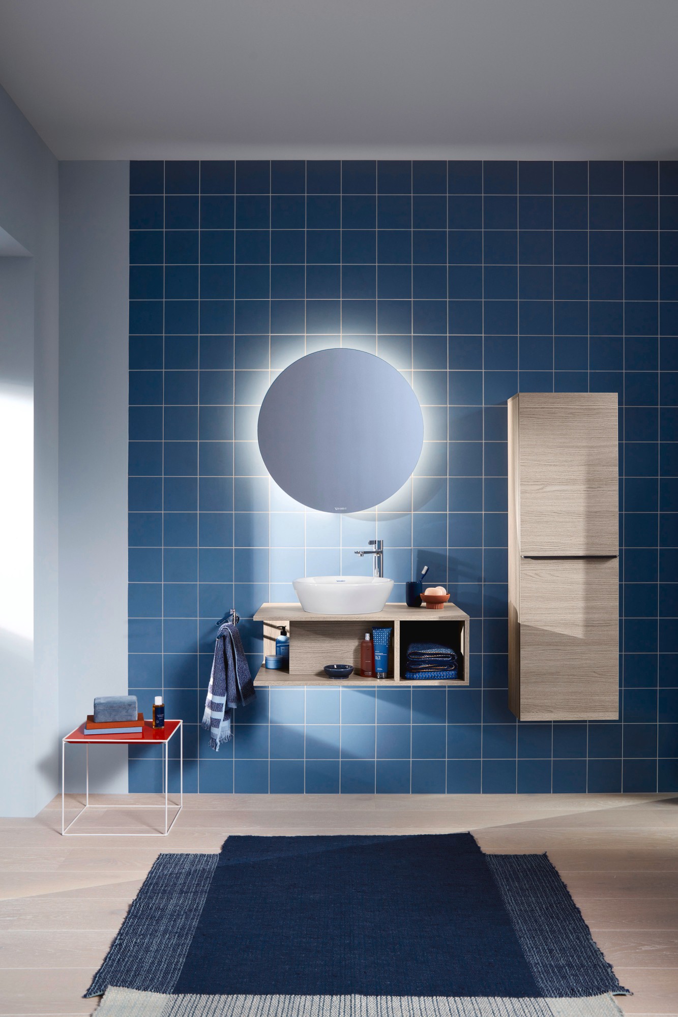 Waschplatz mit Duravit D-Neo Waschtischunterbau, Aufsatzbecken und Hochschrank vor blau gefliester Wand