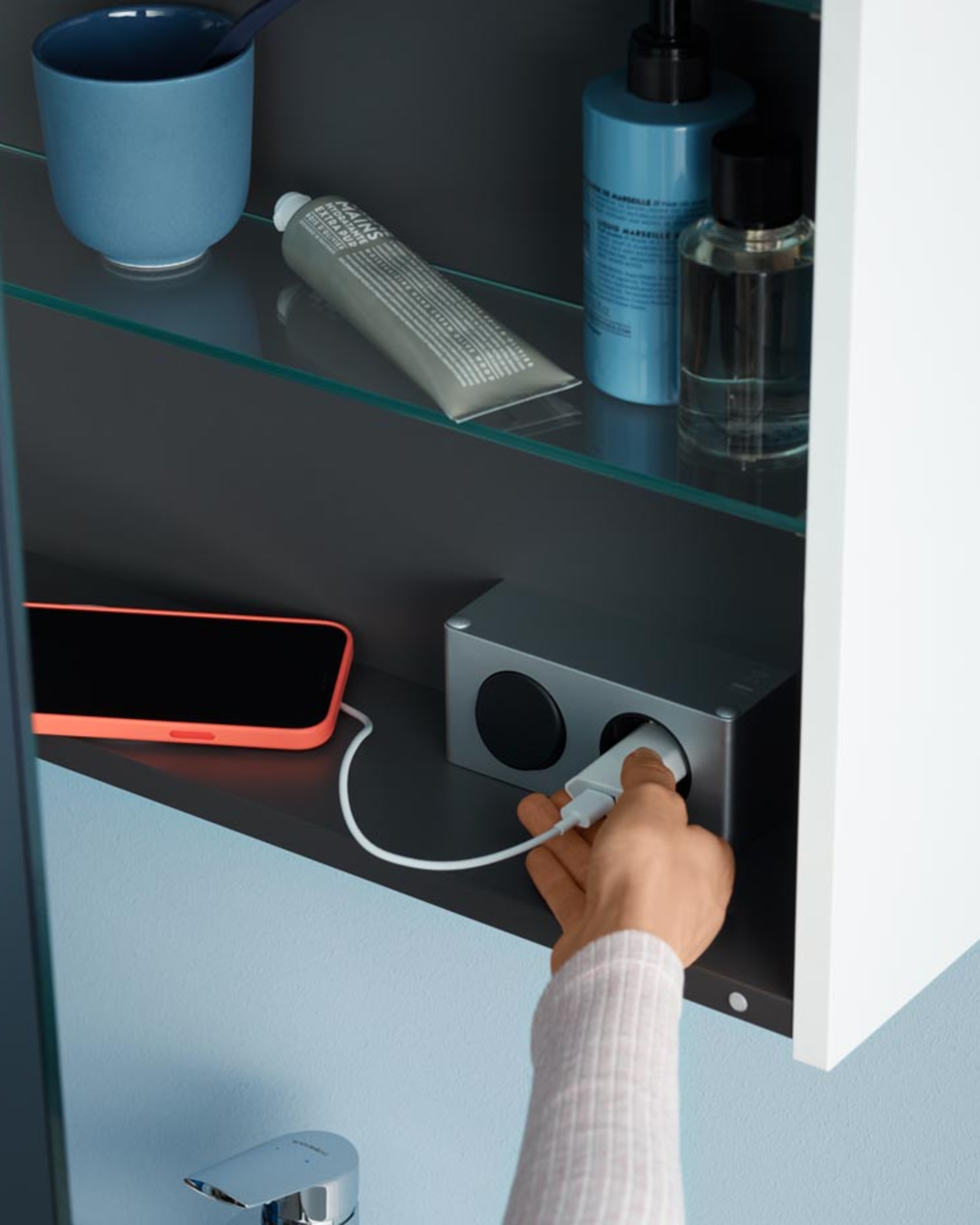 Aufladen eines Handys in einem Spiegelschrak der Serie Duravit No.1