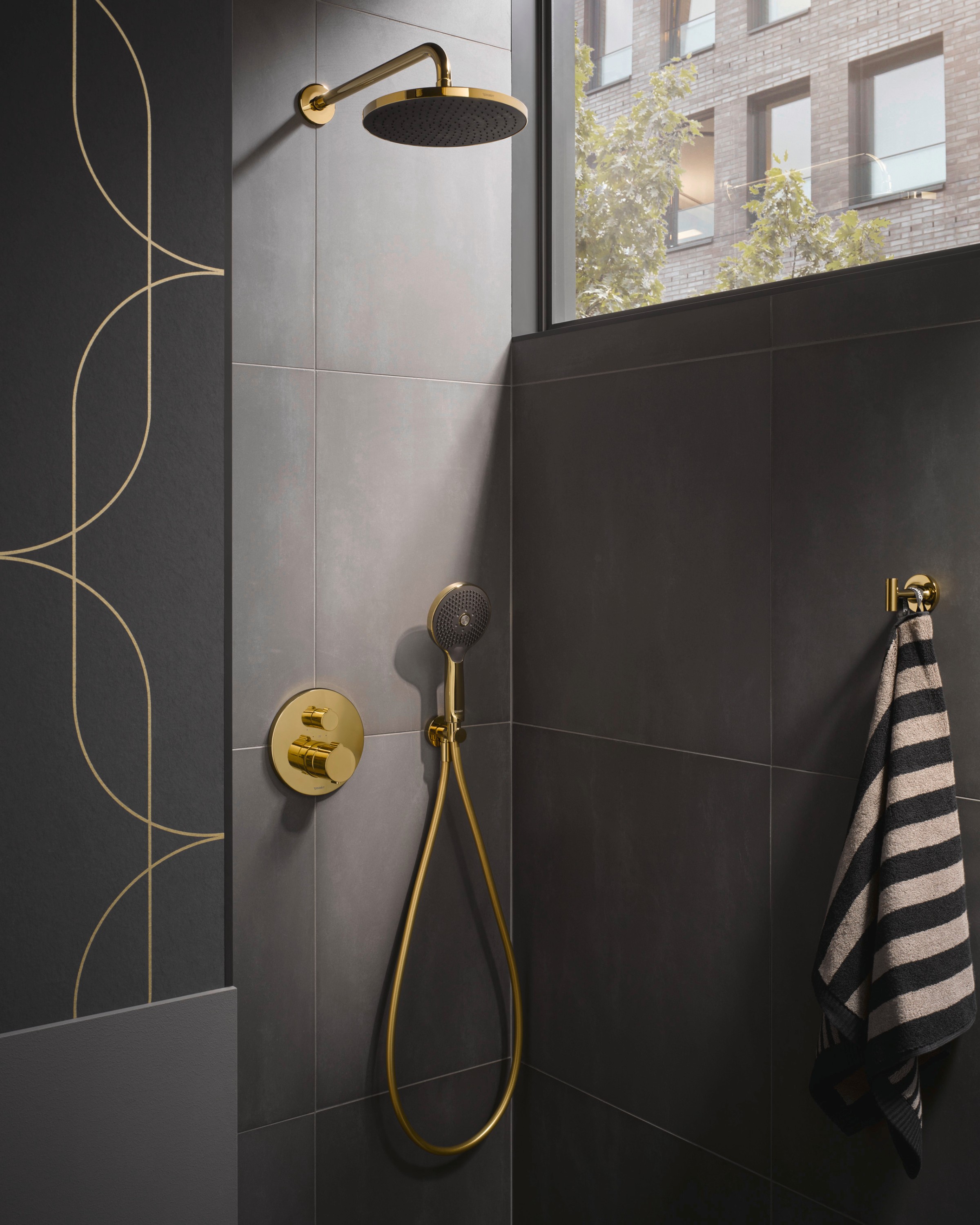 Concealed shower faucet from the Duravit Wave series and a hand shower in polished gold