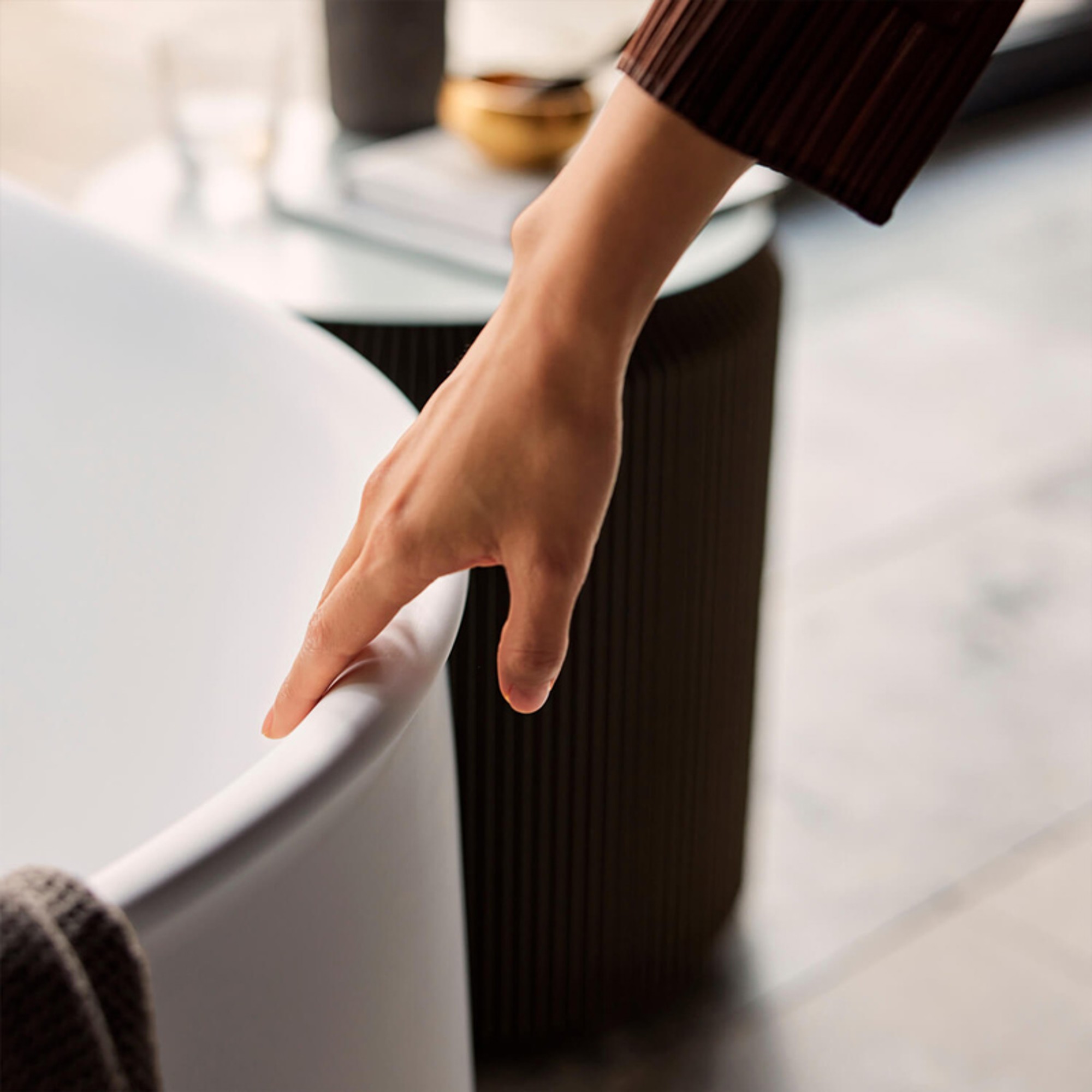 Hand streicht über den geschwungenen Rand einer Duravit Zencha Badewanne