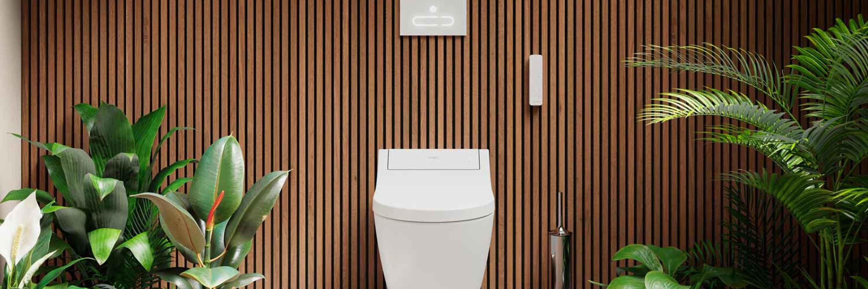 Toilet in front of wood-paneled wall with plants on the side