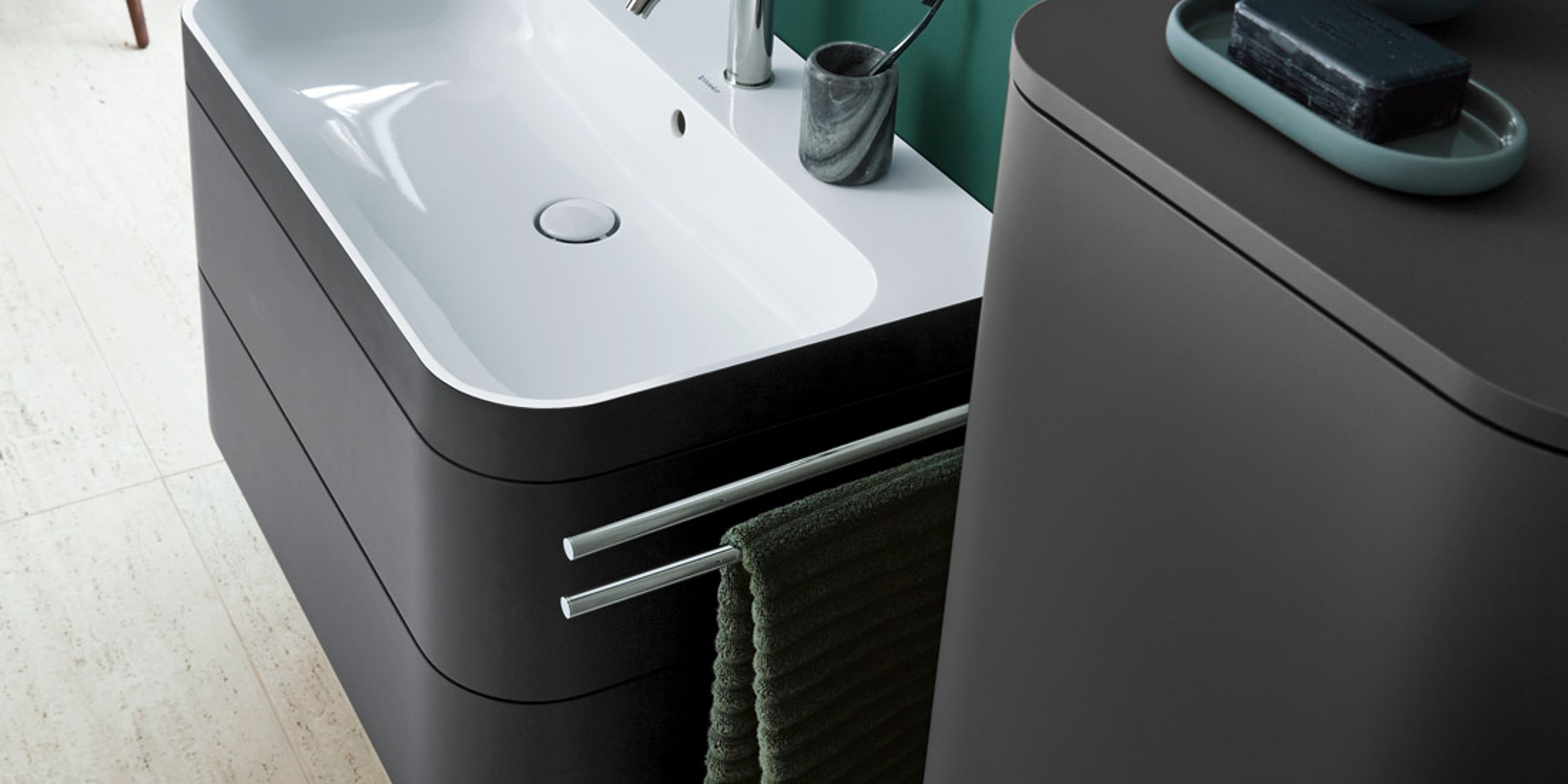 Bathroom with green accent wall, sink area, and ceramics from the Duravit Happy D.2 series.