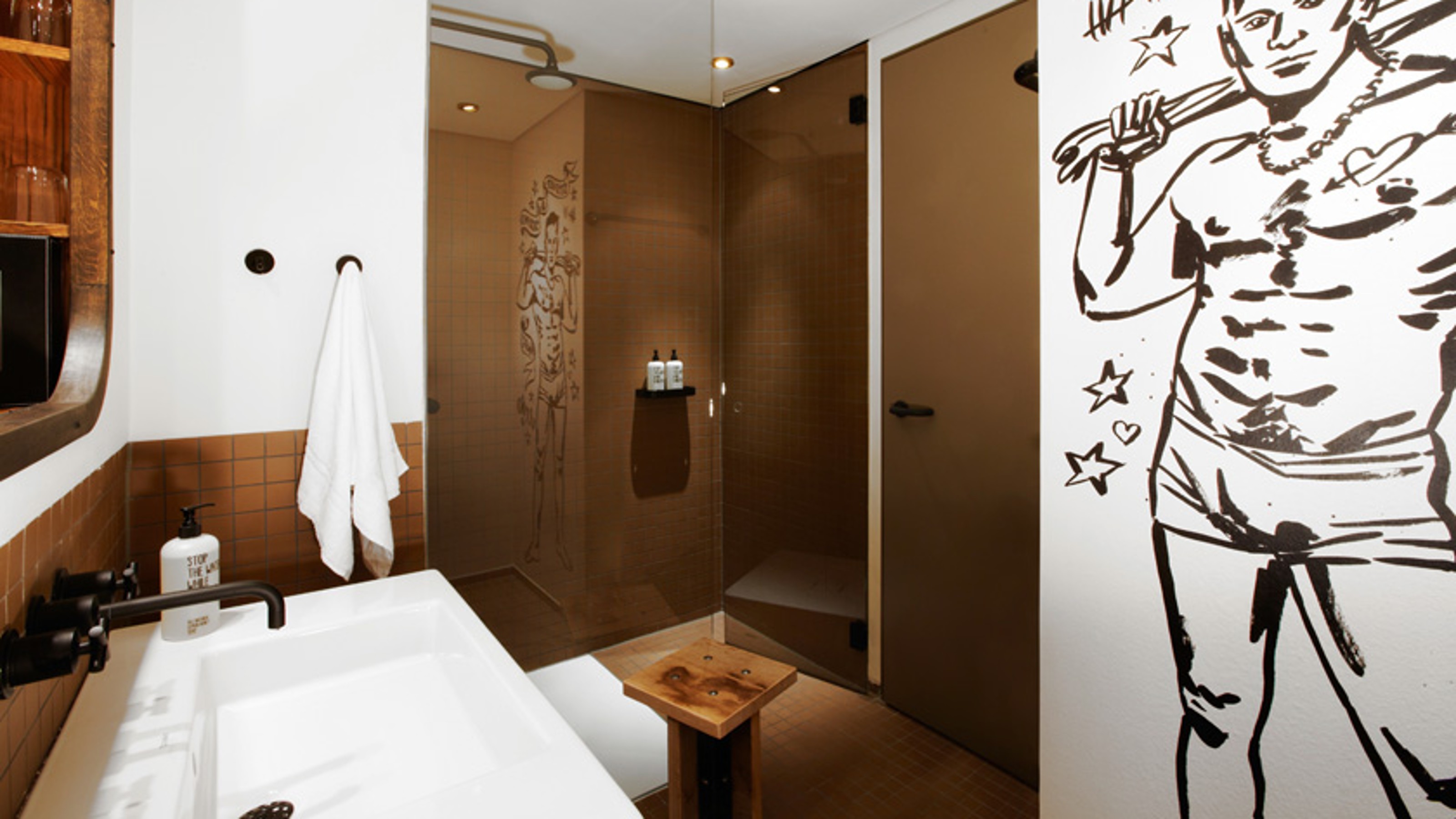 25hours Hotel Hafen City Hamburg, Badezimmer, Waschplatz links, Dusche mittag, rechts ein Gemälde