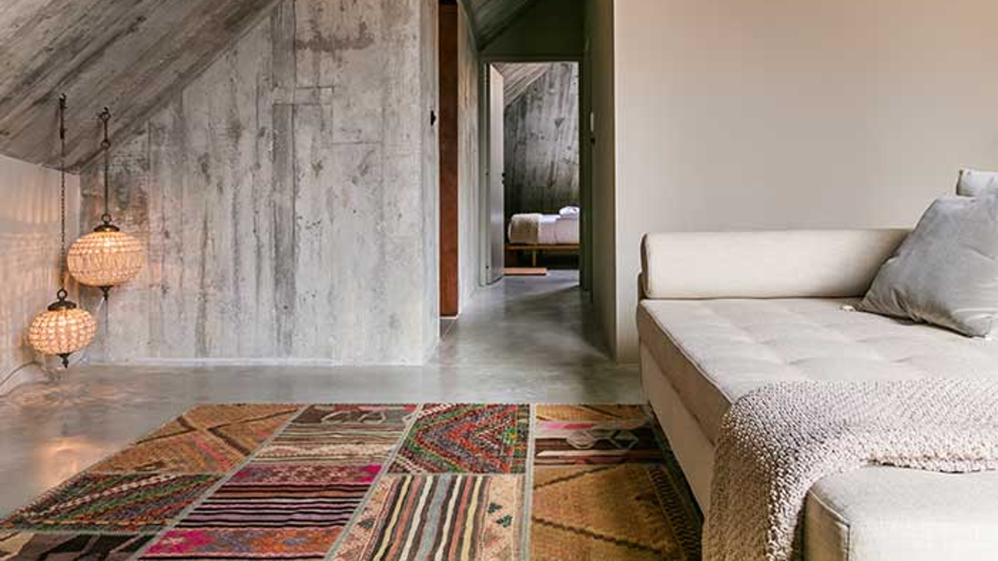 Armazem Luxury Housing, sofa on the right with carpet, view of the bedroom in the background