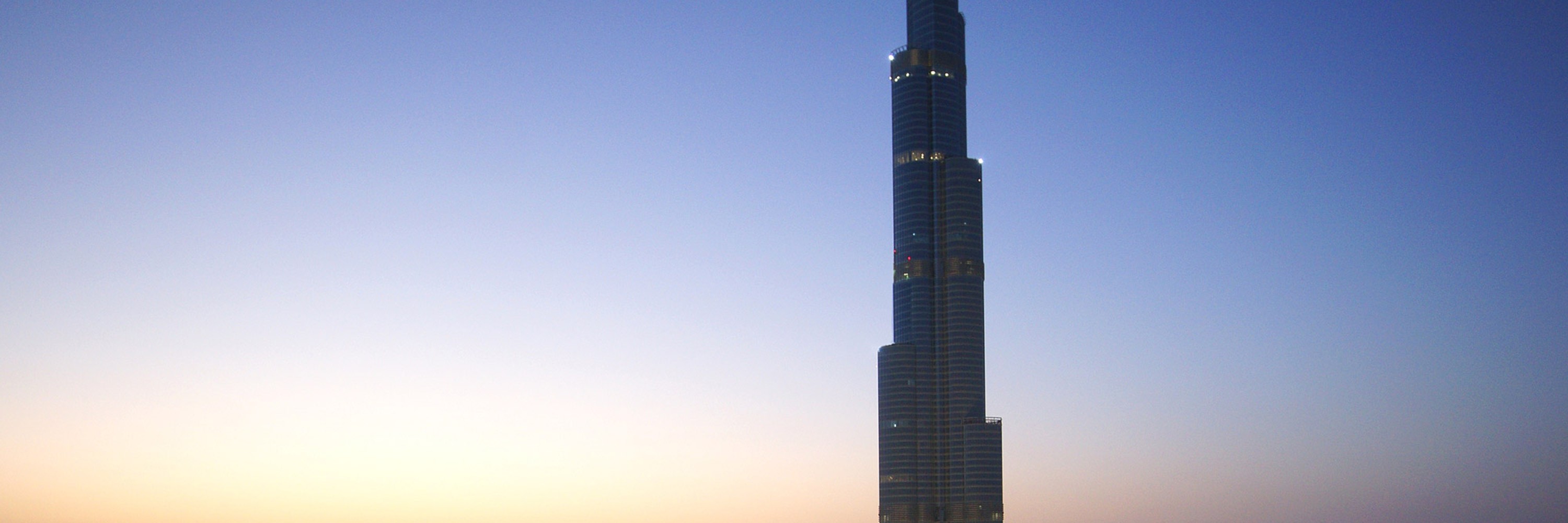 Burj Khalifa, beleuchtetes Gebäude von außen bei Dämmerung