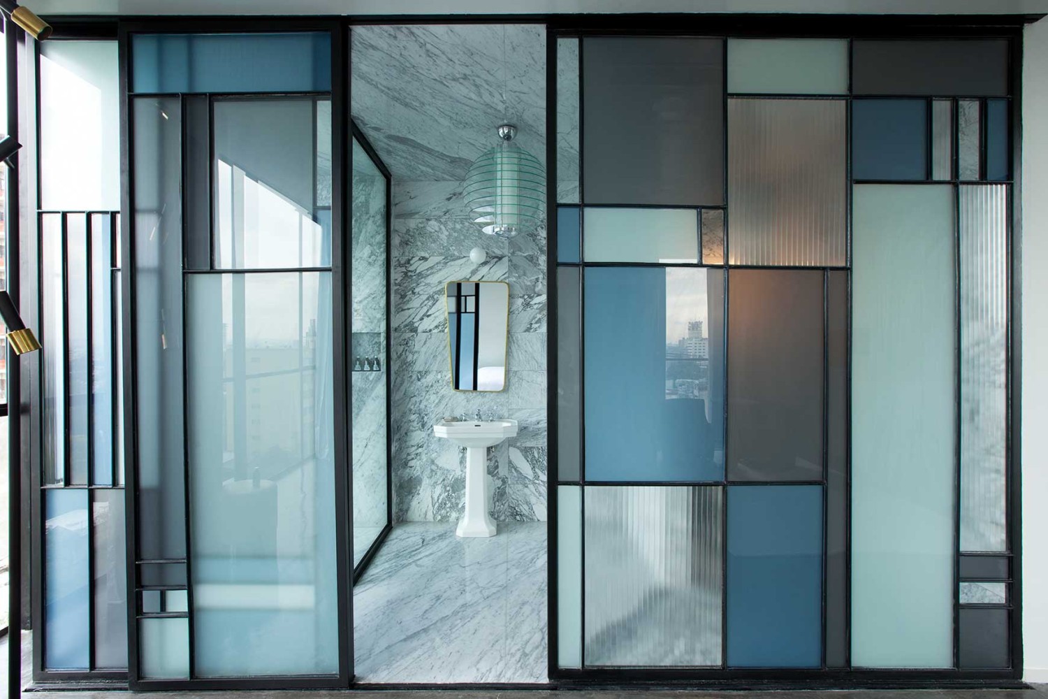Casa Fayette, view of the bathroom with the door open onto the washbasin area, glass wall with different coloured panes