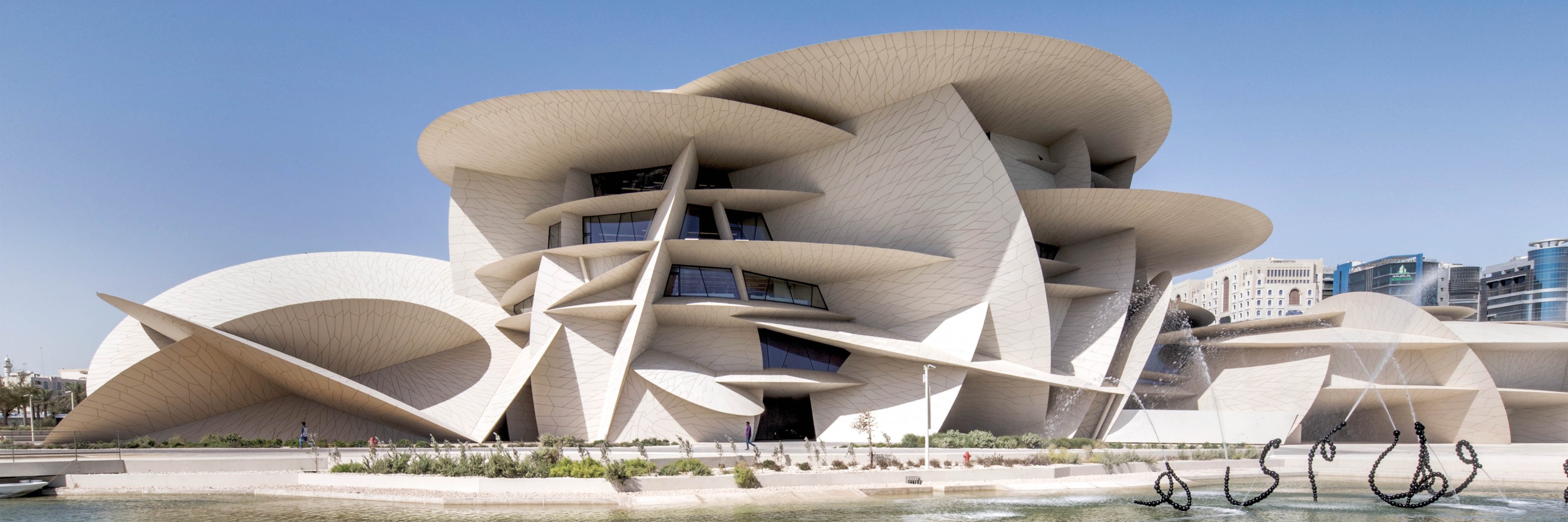 Qatar National Museum, exterior view of the building with water in the foreground