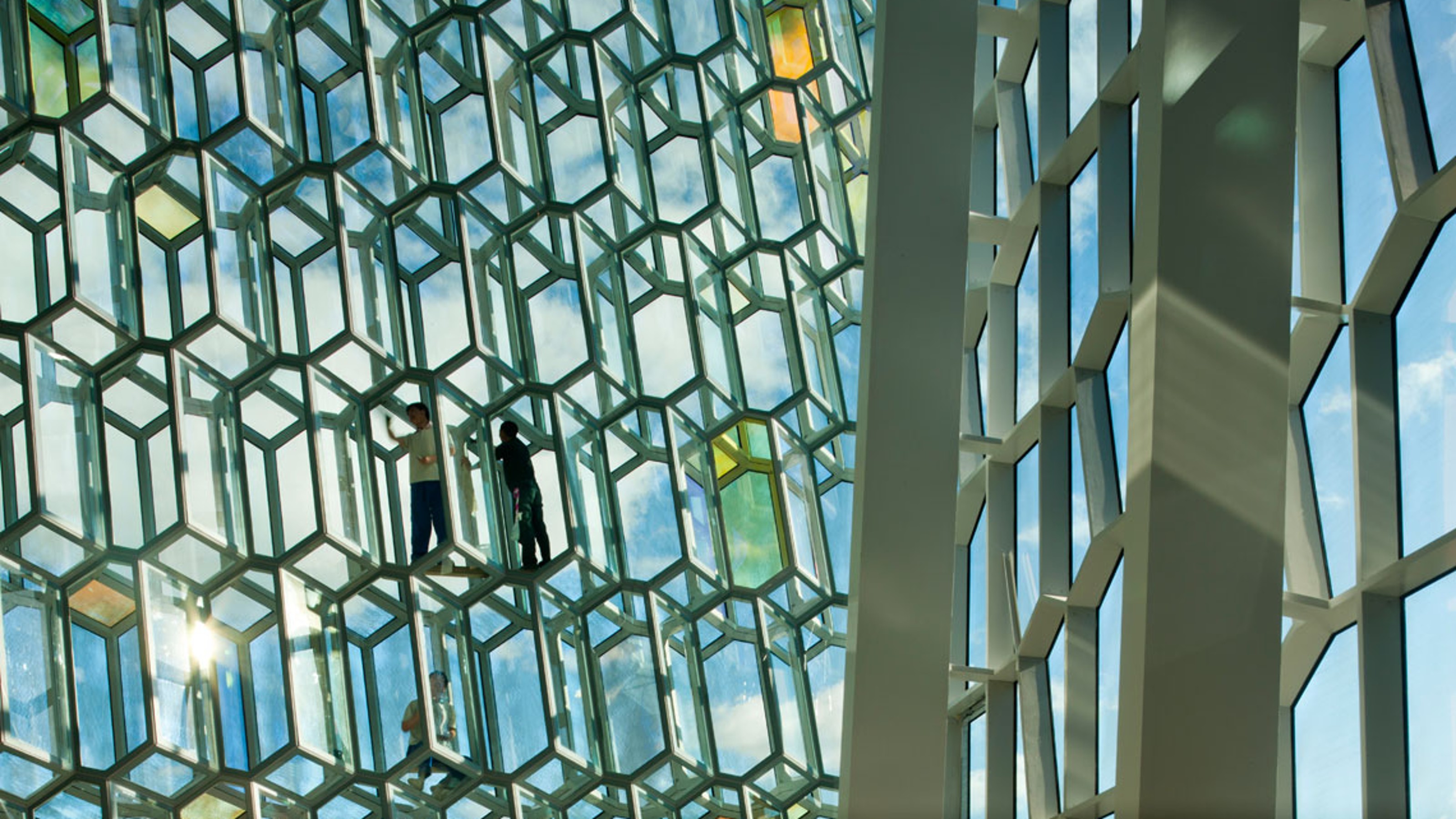 Harpa Concert Hall, detailed view of the glass façade through which a couple is walking