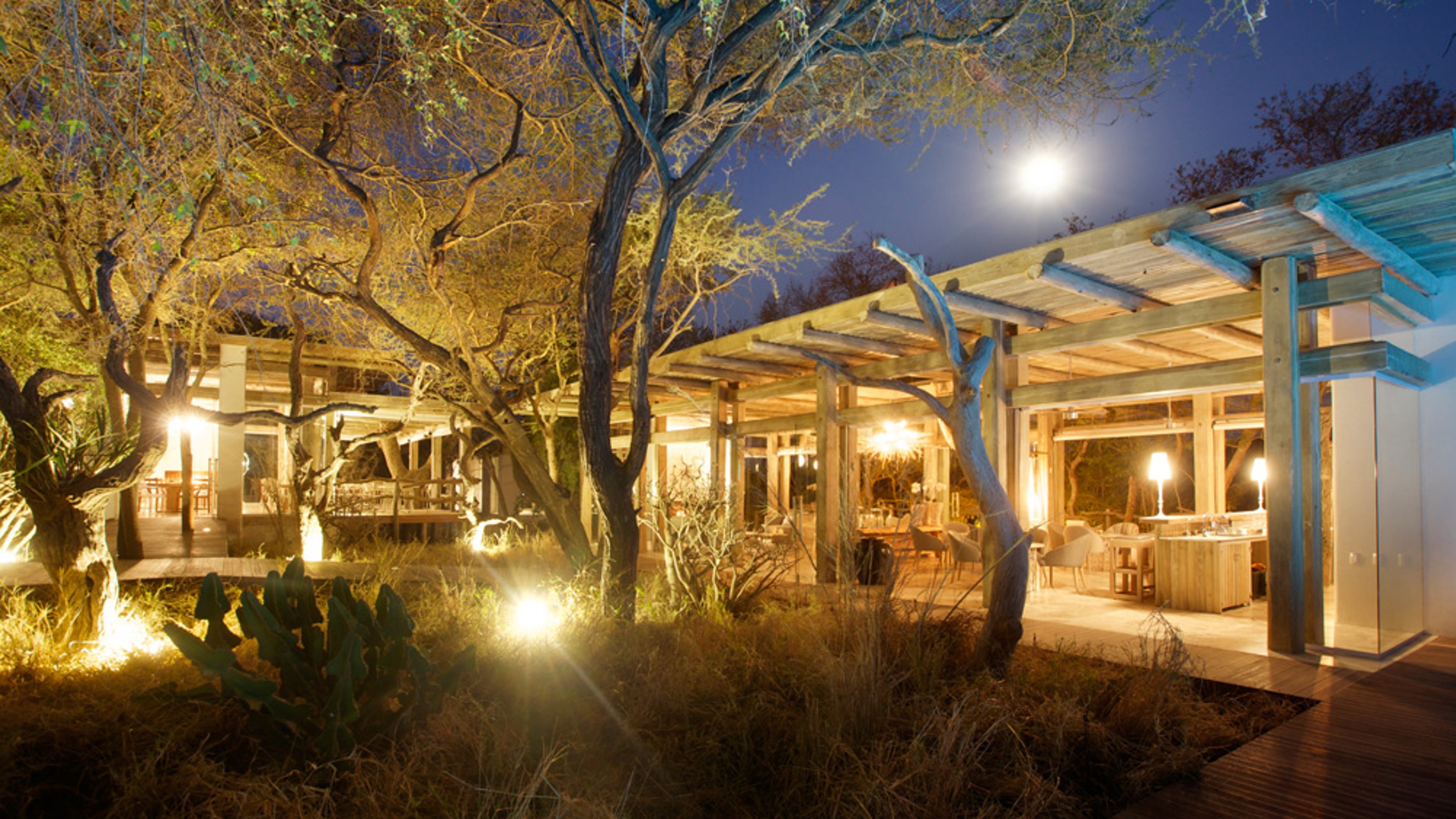Kapama Karula Lodges, illuminated dining and lounge area from the outside at dusk