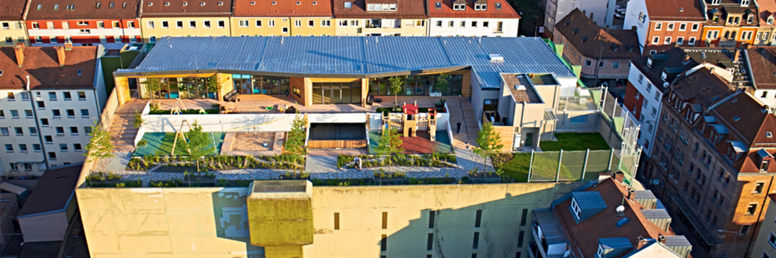 KiTa Wolke 10, bird's-eye view of the exterior of the building, with outdoor area and residential building surrounding it