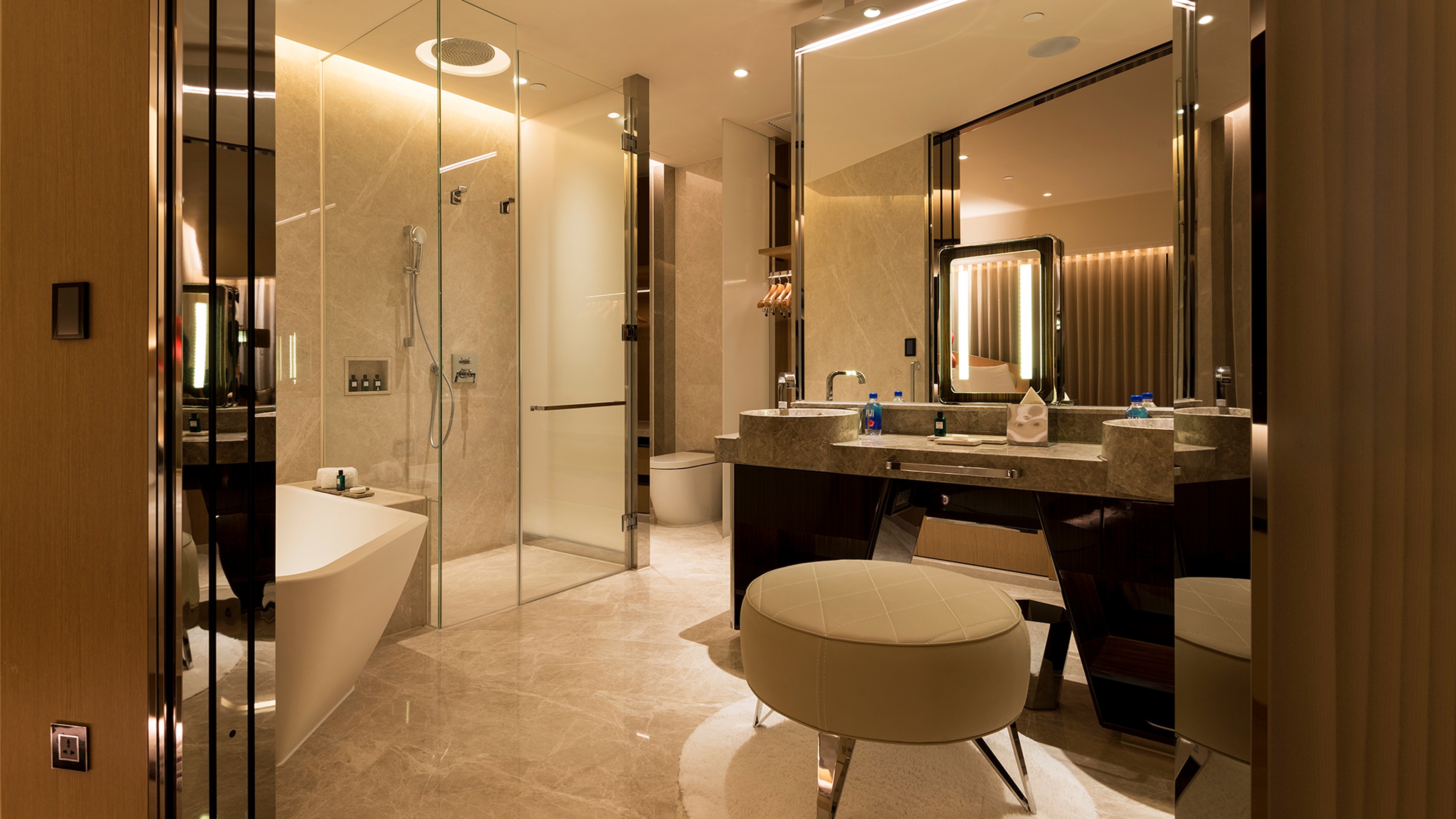 Morpheus Hotel Macau, bathroom with bathtub and shower on the left, toilet in the centre in the background and washbasin on the right
