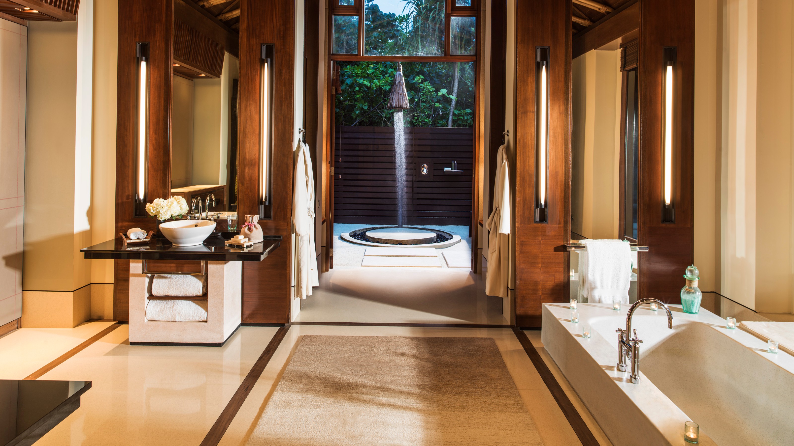 One & Only Reeti-Rah, Badezimmer mit Waschplatz links, Badewanne rechts und Blick nach draußen zur Außendusche