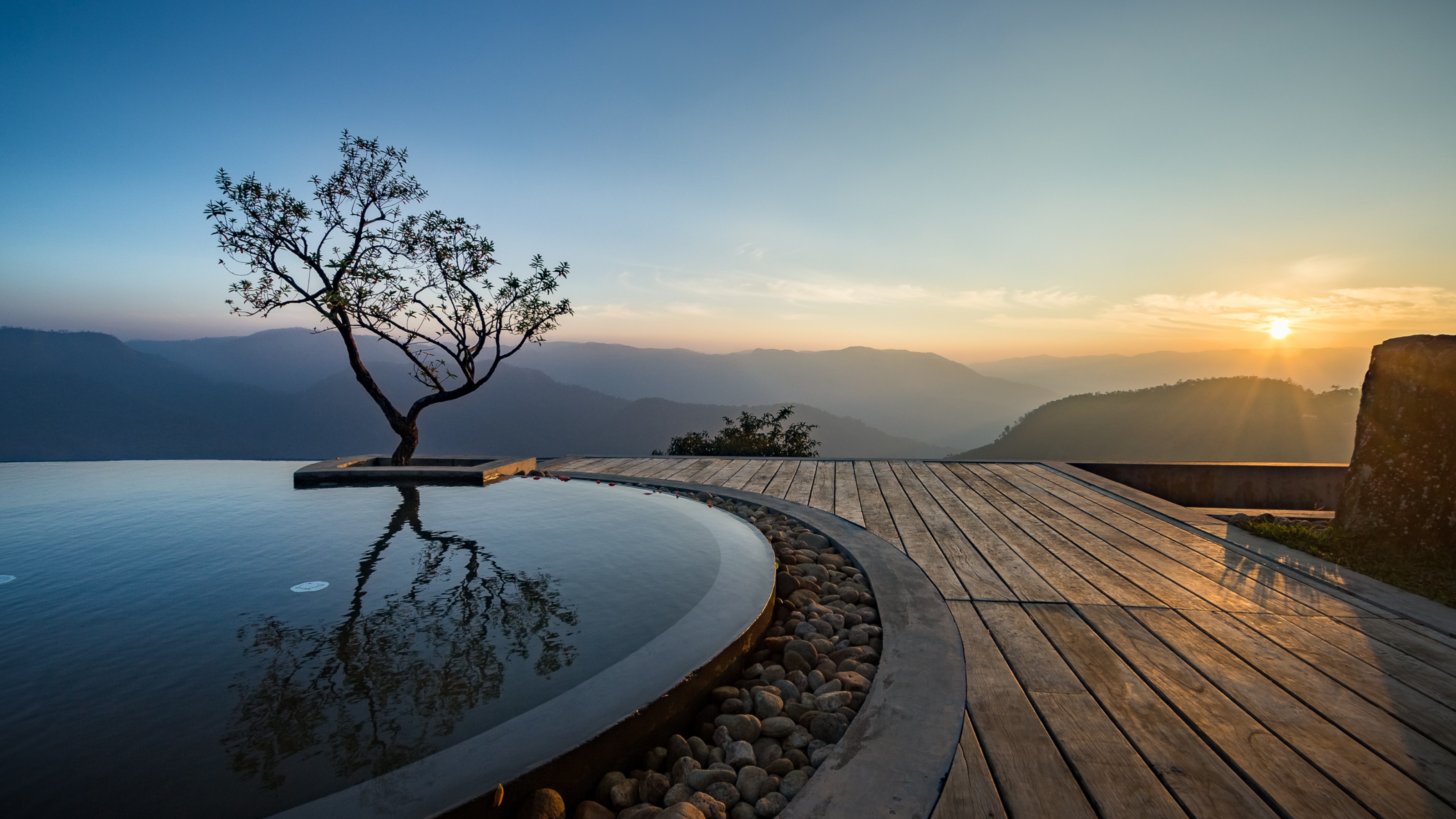Prakriti Shakti Resort, view from the terrace with pool on the left and mountains with sunset in the background