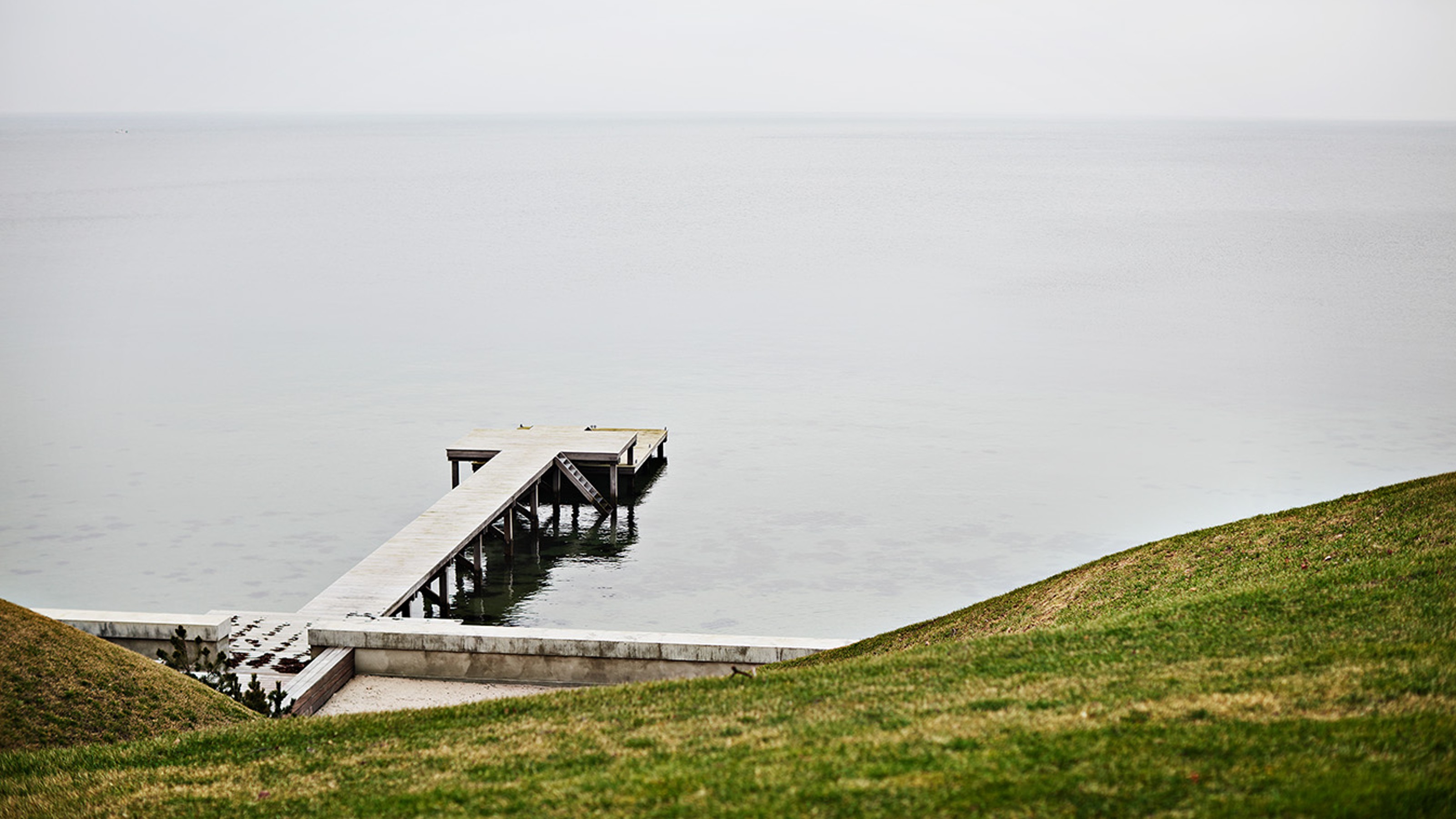 Strandridergården, Blick aufs Meer, in das ein Steg ragt