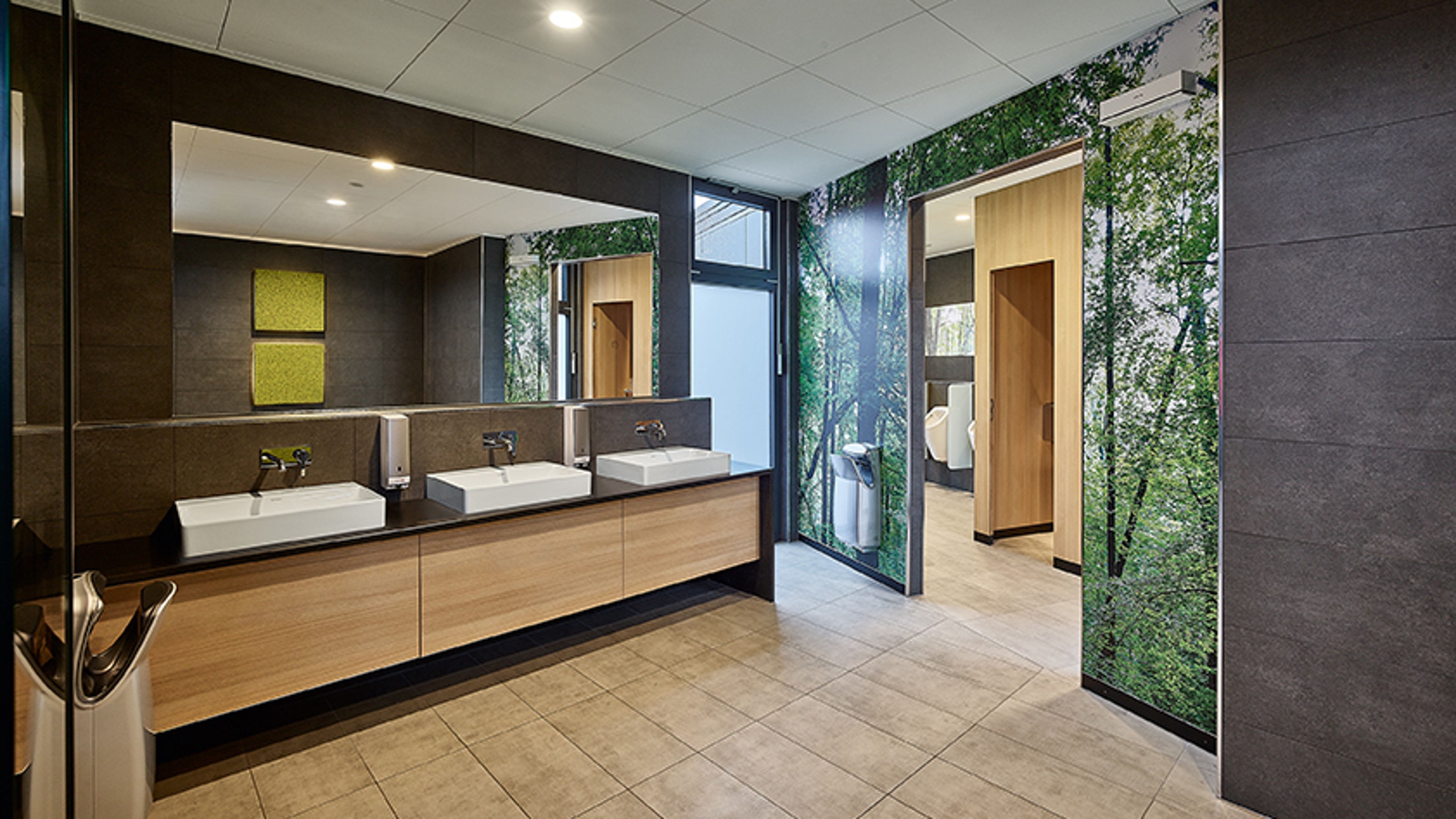 Toilet facilities in Titisee from the inside, view of three washbasins on the left and urinals and toilet cubicles on the right in the background