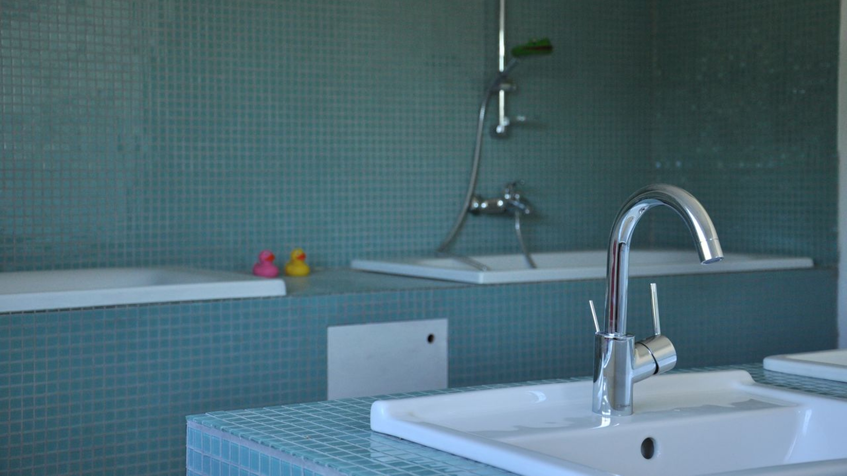 Ukuqala, bathroom with washbasin in the foreground and bathtubs in the background