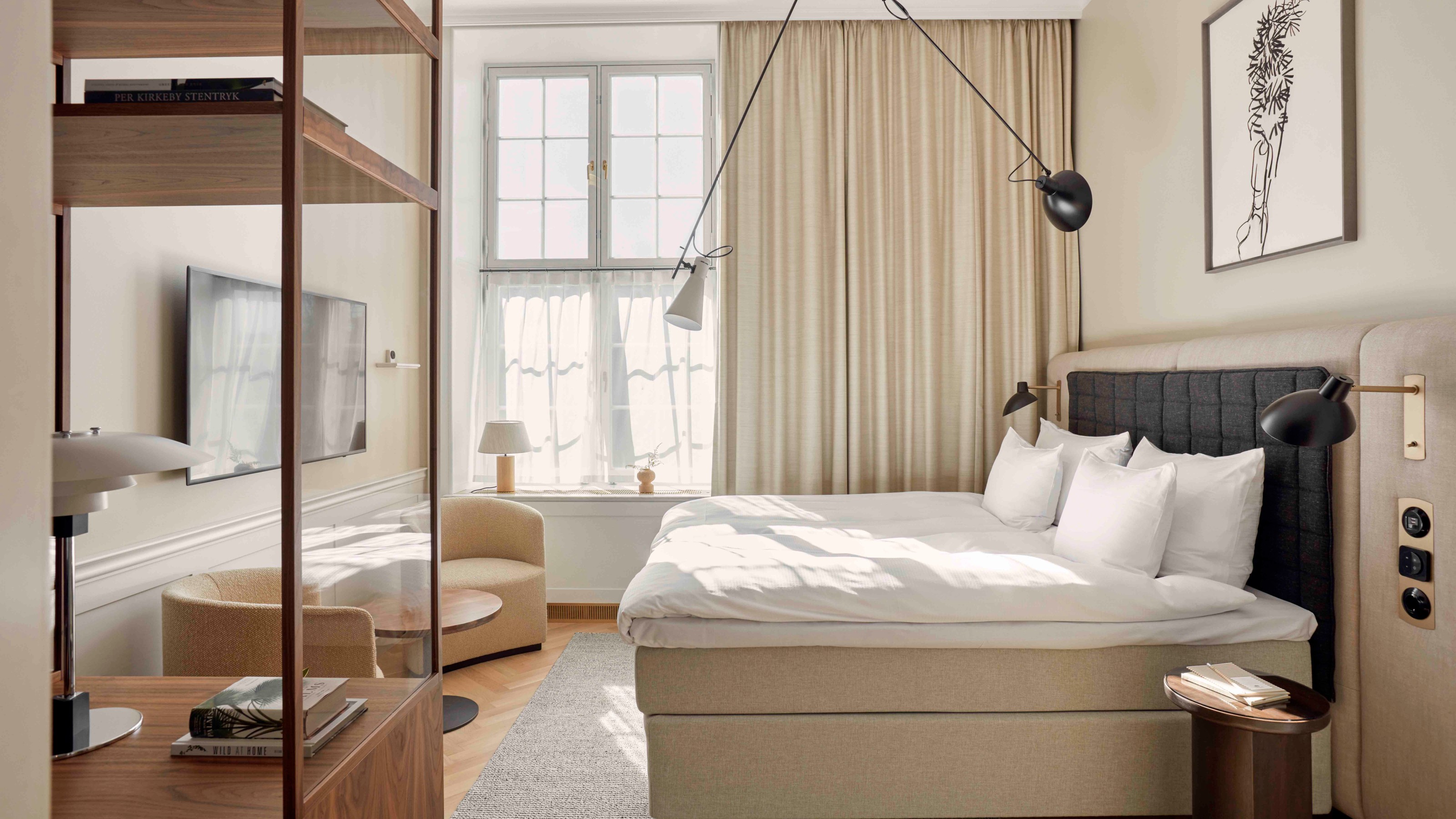 Villa Copenhagen, hotel room with bed on the right and seating and shelves on the left