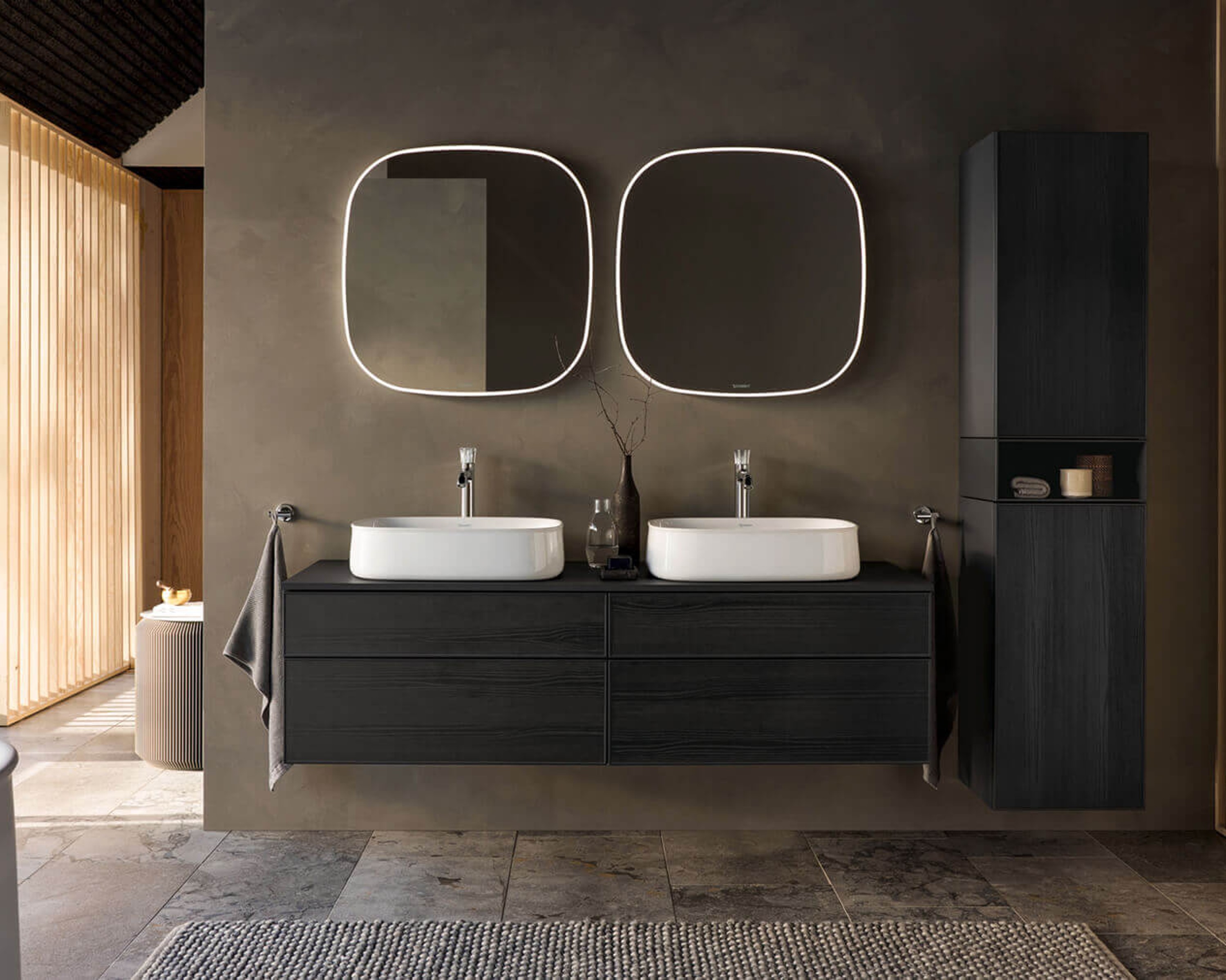 A double washbasin made of dark wood with two rounded mirrors hanging above it.