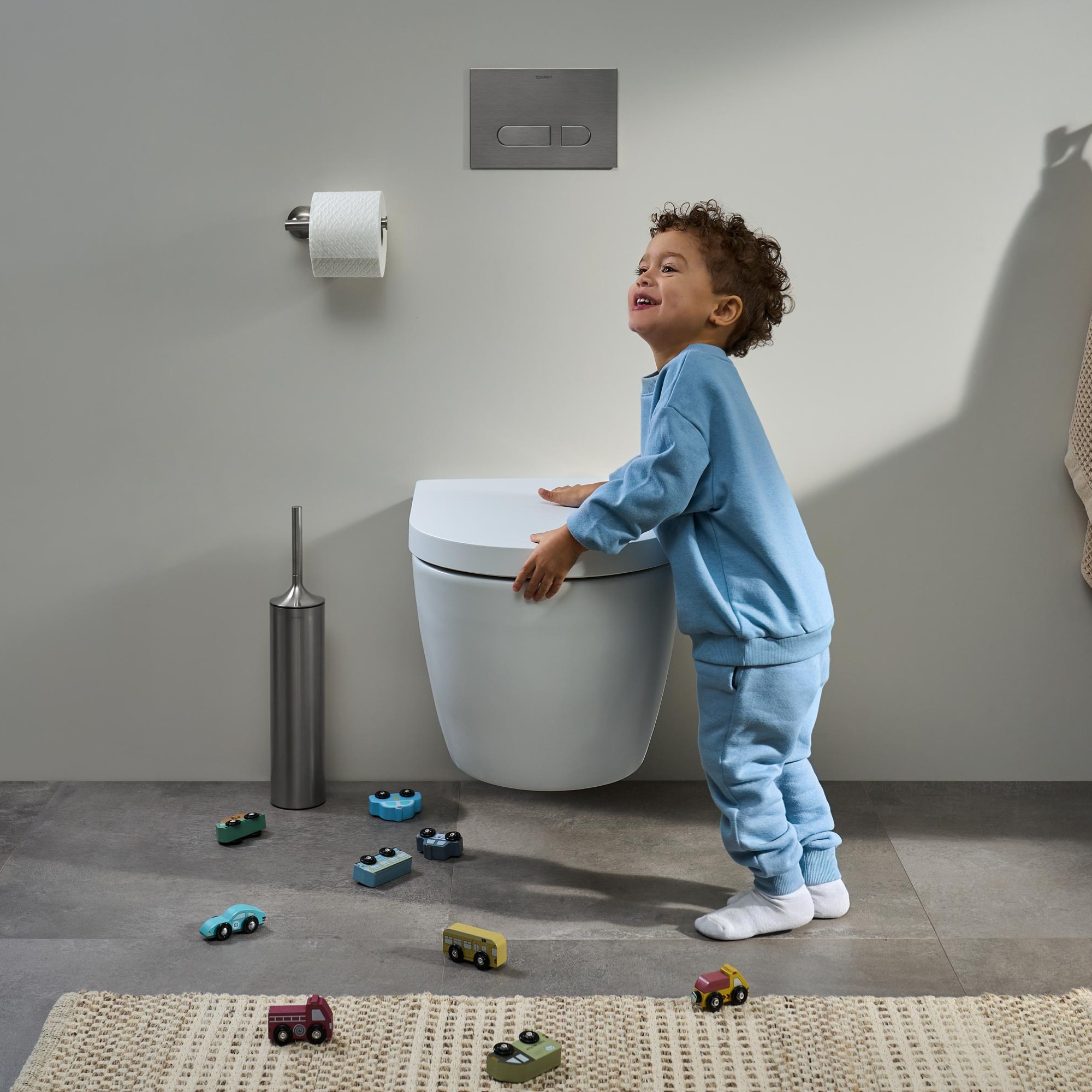 A child is playing next to a Duravit toilet