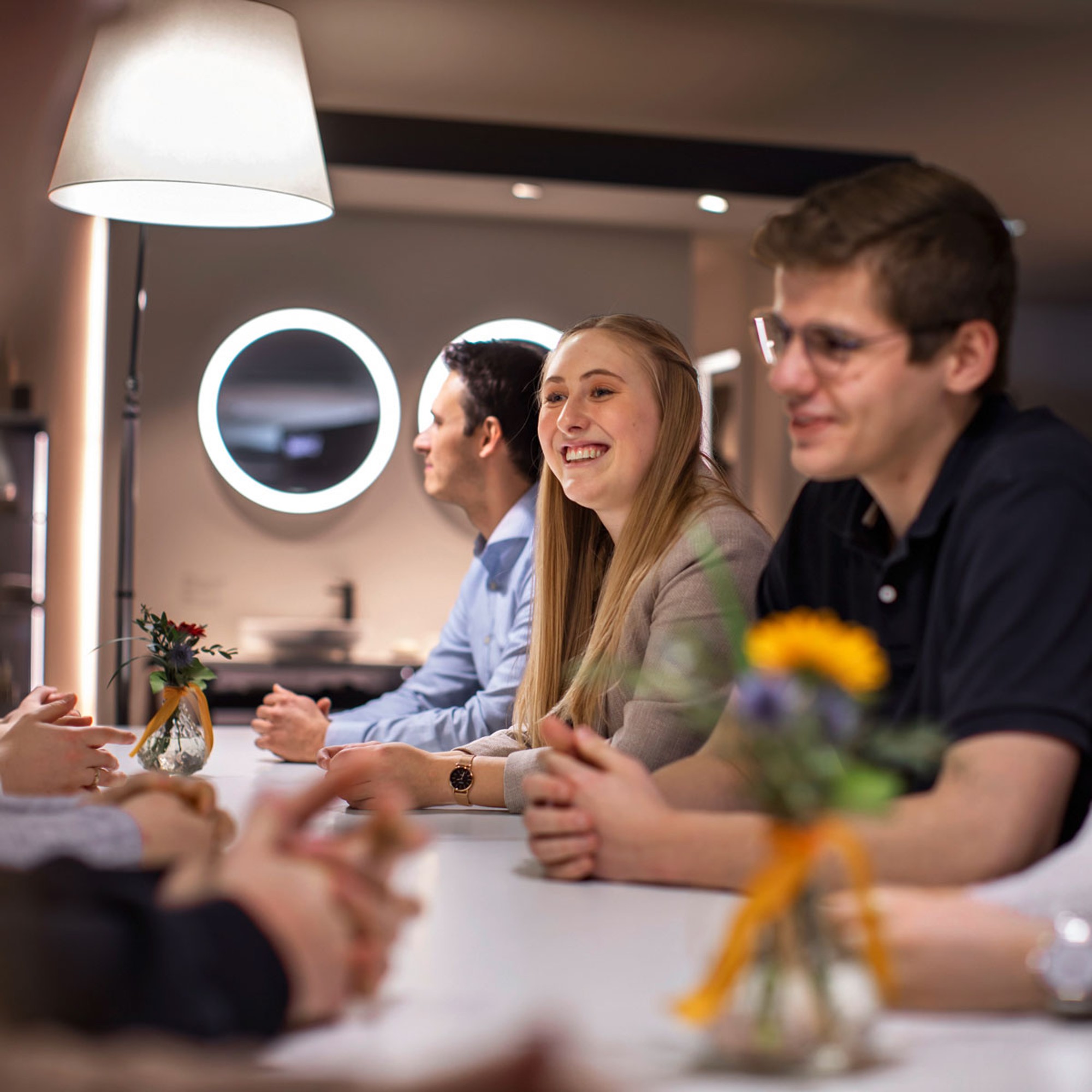 Junge Studierende sitzen bei Duravit an einem langen Tisch.