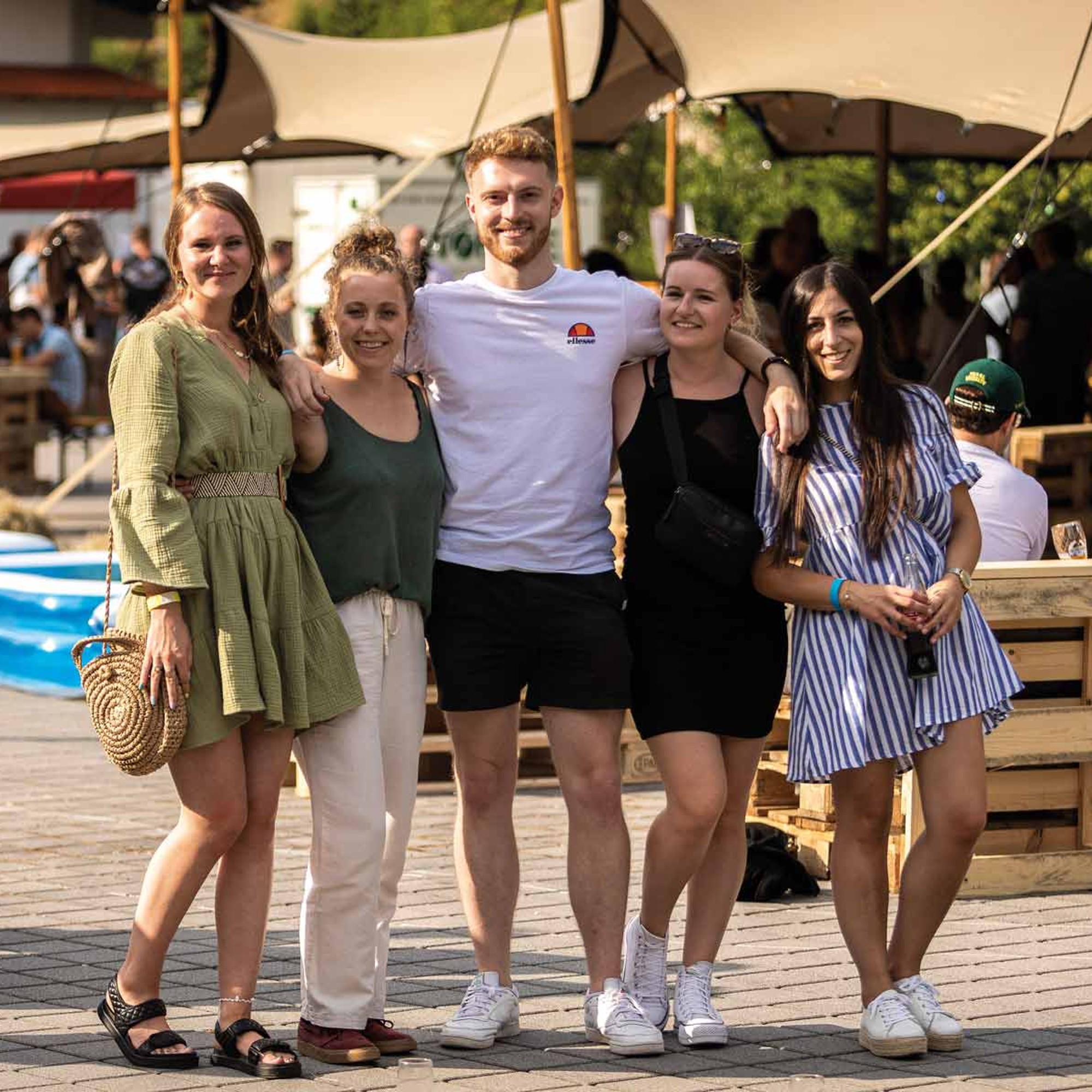 Junges Kollegium bei einem Sommerfest in einem Beach Club.