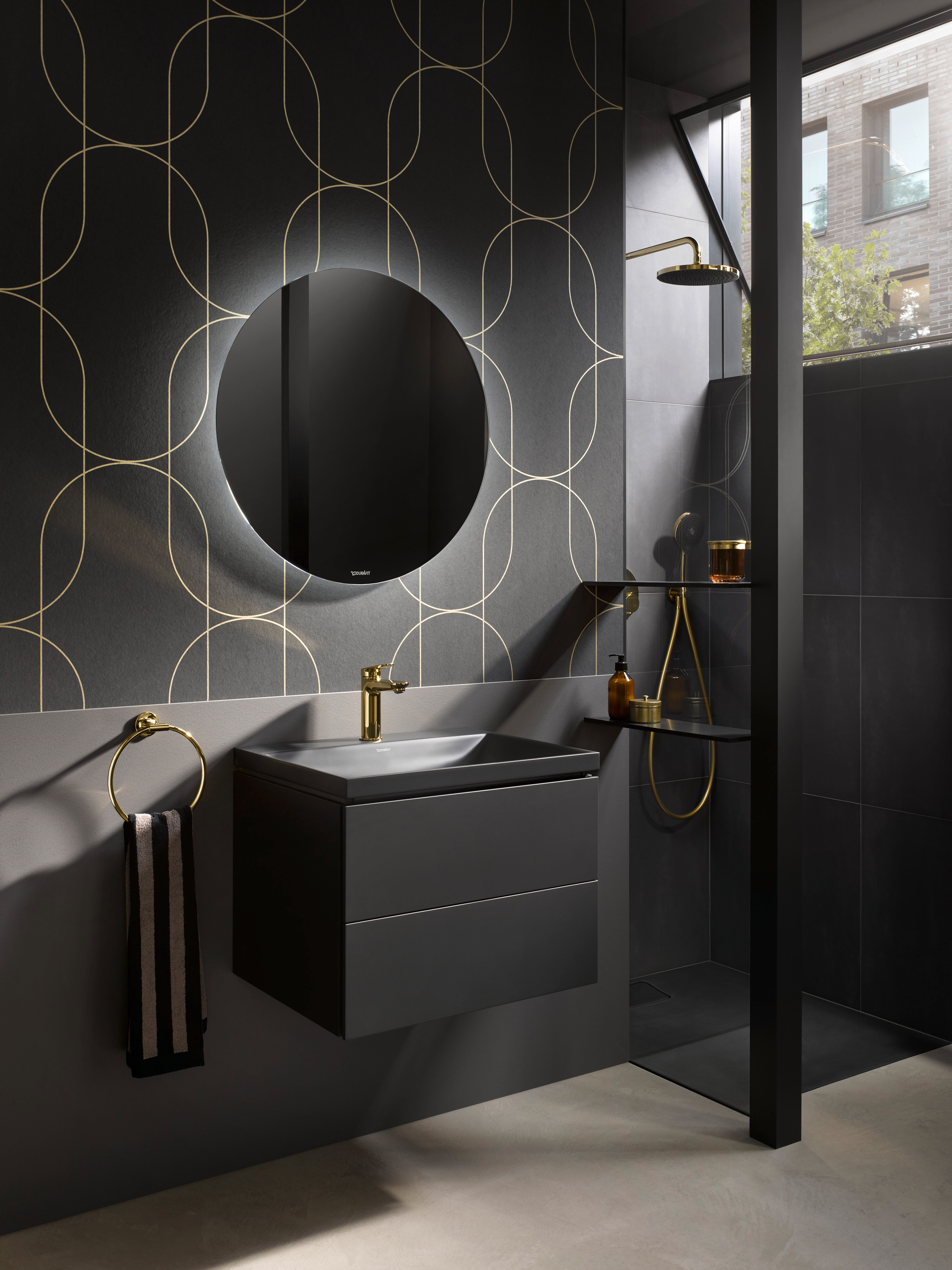 Schwarz eingerichtetes Badezimmer mit Armaturen der Serie Duravit Wave in Gold poliert