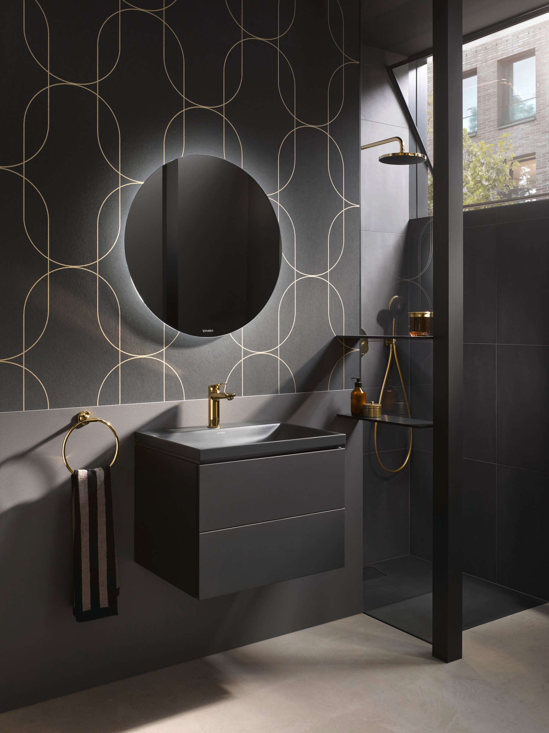 Black bathroom with Duravit Wave series faucets in polished gold