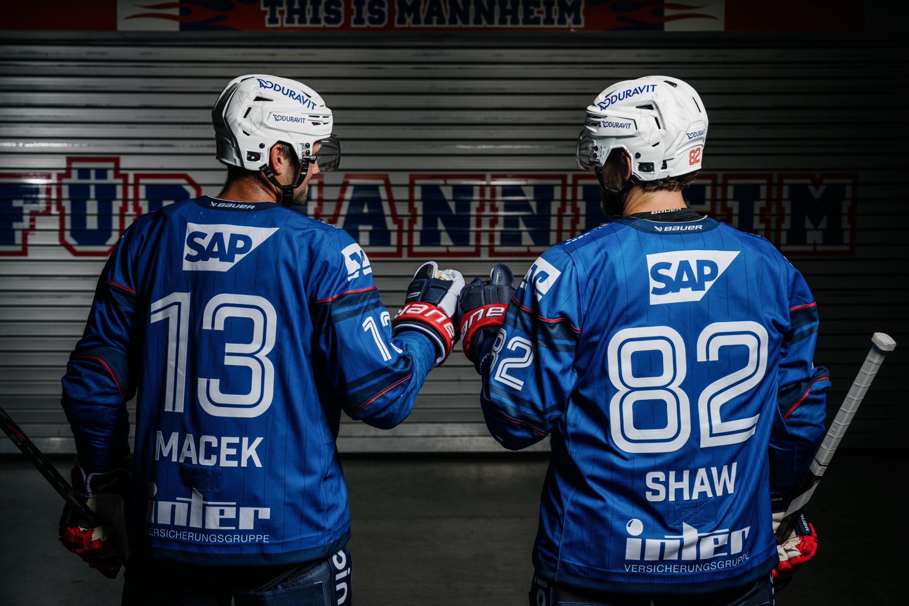 Two ice hockey players from the Mannheim Adler high-five each other