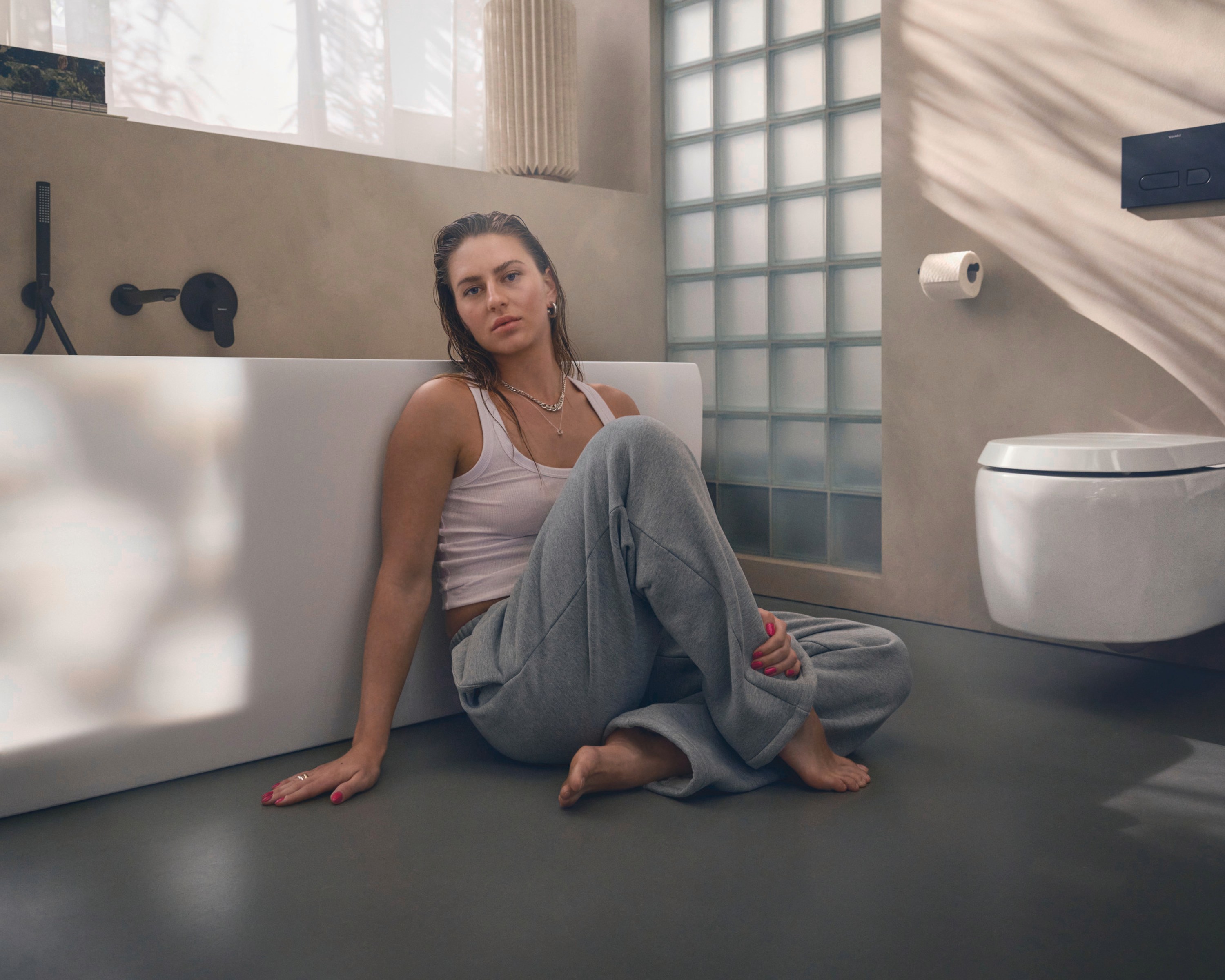 Person lehnt sich sitzend an eine Collection One Badewanne