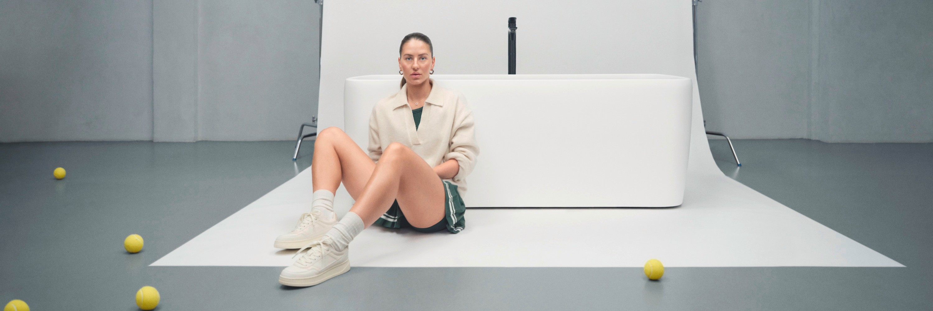 A woman is sitting in front of a bathtub from Duravit's Studio F. A. Porsche Collection